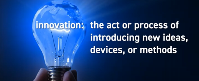 Hand holding a glowing blue lightbulb with a definition of 'innovation' in white text on a dark background.
