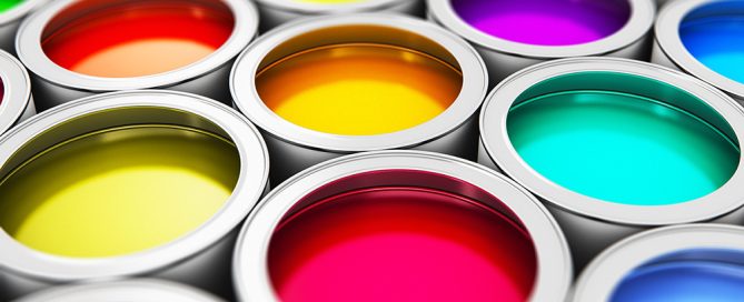 Open paint cans from above displaying a full spectrum of vibrant liquid paint colors with a paint brush.