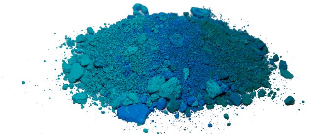 Pile of teal and blue pigment powder blending from lighter turquoise to deeper blue shades against a white background.