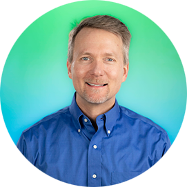 Professional headshot of a man wearing a light blue shirt against a turquoise-to-blue gradient circular background.